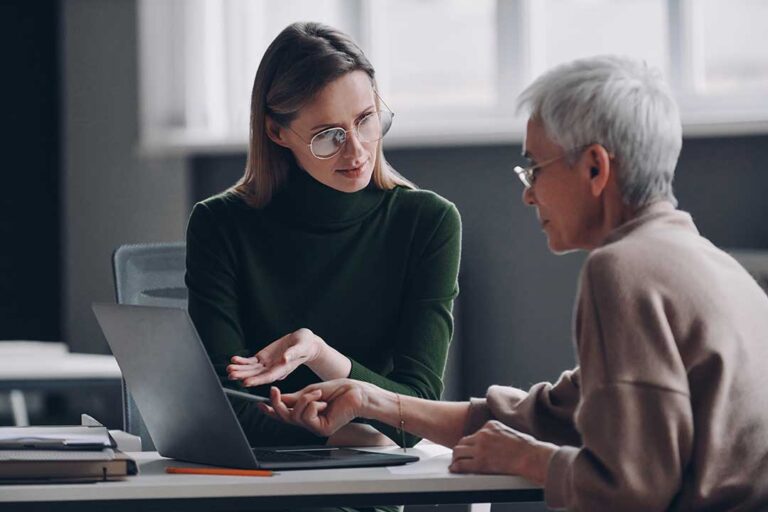 Homeowner reviews an insurance policy beside storm photos, receipts, and a home inventory folder.